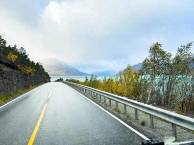 Norveç 'in Lyngen Alpleri' nin sonbahar manzarasında yol kenarına parketmiş bir karavan..