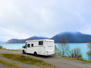 Norveç 'in Lyngen Alpleri' nin sonbahar manzarasında yol kenarına parketmiş bir karavan..