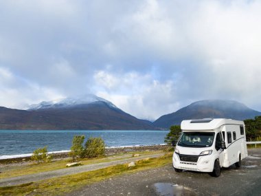 Norveç 'in Lyngen Alpleri' nin sonbahar manzarasında yol kenarına parketmiş bir karavan..