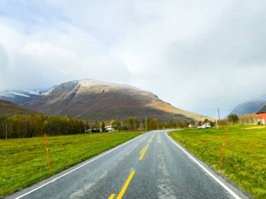 Norveç 'in Senja Adası' nın sonbahar manzarasında, fiyortları ve dağları olan bir karavan..