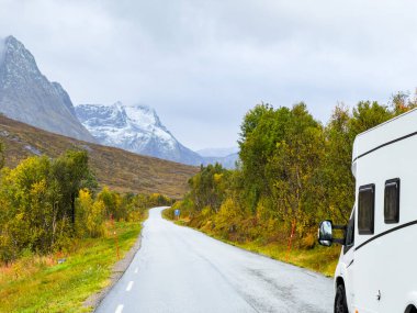 Norveç 'in Senja Adası' nın sonbahar manzarasında, fiyortları ve dağları olan bir karavan..