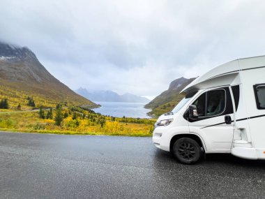 Norveç 'in Senja Adası' nın sonbahar manzarasında, fiyortları ve dağları olan bir karavan..