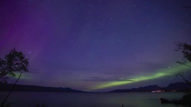 Aurora Borealis zaman dilimi Kiruna, İsveç yakınlarındaki göle yansıyor.