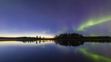 Aurora Borealis zaman dilimi Kiruna, İsveç yakınlarındaki göle yansıyor.