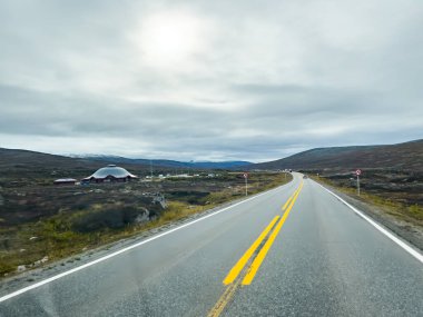 Norveç 'teki dağlık bir arazide bulutlu bir gökyüzünün altında uzanan manzara rotası