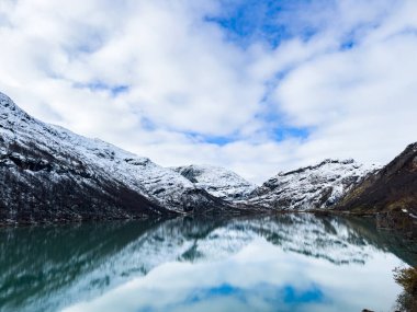 A winter landscape along the Sognefjellsvegen road in south Norway, featuring snow-covered mountains and a vast, serene terrain. clipart