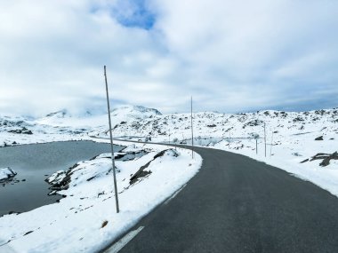 Norveç 'in güneyindeki Sognefjellsvegen yolu boyunca uzanan kış manzarası, karla kaplı dağlar ve geniş, sakin bir arazi içerir..
