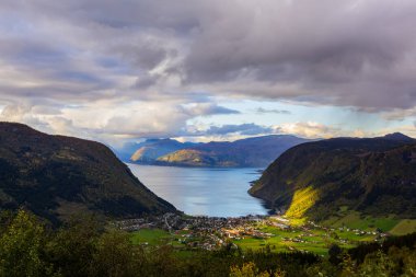 Norveç 'in Viksuri köyünün üzerinde gün batımı, dağlarla ve fiyortlarla çevrili, canlı sonbahar renkleriyle..
