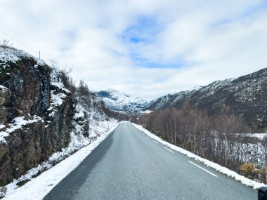 A winter landscape along the Sognefjellsvegen road in south Norway, featuring snow-covered mountains and a vast, serene terrain. clipart