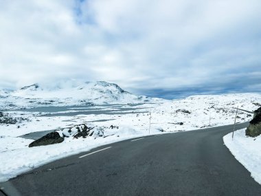 Norveç 'in güneyindeki Sognefjellsvegen yolu boyunca uzanan kış manzarası, karla kaplı dağlar ve geniş, sakin bir arazi içerir..