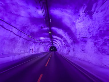 Illuminated purple road passing through laerdal tunnel in norway clipart