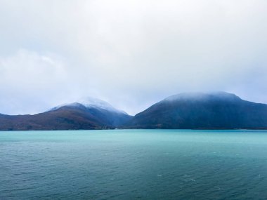 Norveç 'teki Lyngen Alpleri' nin sonbahar manzarası. Karlı zirveleri, dramatik bulutları ve sakin fiyortları var..