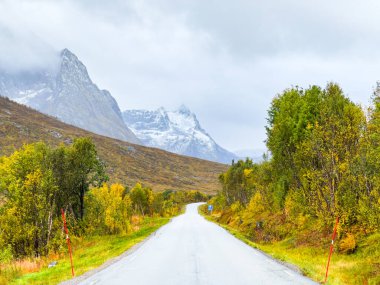 Norveç 'in Senja Adası' nın sonbahar manzarasında, fiyortları ve dağları olan bir karavan..
