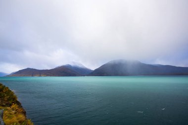Norveç 'teki Lyngen Alpleri' nin sonbahar manzarası. Karlı zirveleri, dramatik bulutları ve sakin fiyortları var..
