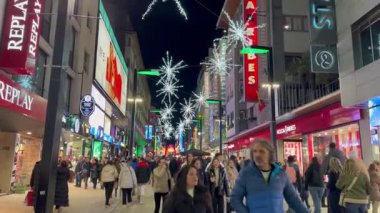 İnsanlar Noel zamanı Andorra La Vella 'daki Meritxell Caddesi' nde yürüyor ve alışveriş yapıyorlar.