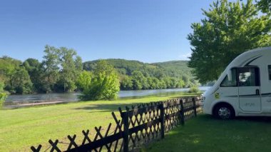 Fransa 'nın La Roque Gageac kentindeki Dordogne nehrinin yakınına park edilmiş beyaz karavan.