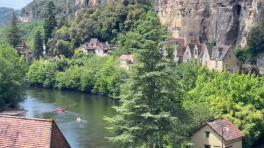 Kayıkçılar Dordogne nehrinin aşağısında güzel bir köy olan La Roque Gageac 'a doğru kürek çekiyorlar.