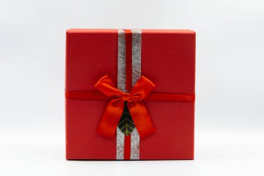 Gümüş kurdeleli kırmızı hediye kutusu ve beyaz arka planda fiyonk, özel durumlar için mükemmel.