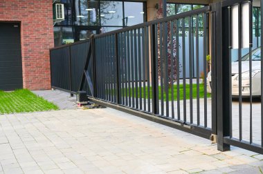 Bir şehir ortamında kablosuz ağ geçidi cihazı görülüyor, belki bir ofis ya da apartman kompleksinde. Şık ve modern tasarım, çevre mimari ve teknolojiyle uyumlu.