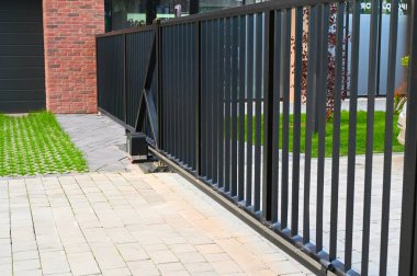 Bir şehir ortamında kablosuz ağ geçidi cihazı görülüyor, belki bir ofis ya da apartman kompleksinde. Şık ve modern tasarım, çevre mimari ve teknolojiyle uyumlu.