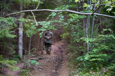 Kıdemli avcı ormanda yürüyor.