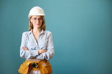 Arka planda çapraz elleri olan genç kadın işçinin portresi. Yeni bir proje planlayan beyaz bir kadın. Stüdyoda portre. Boşluğu kopyala.