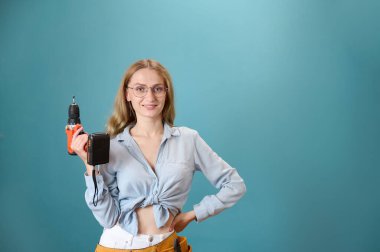 Koruyucu kasklı genç bir kadın işçi arka planda izole edilmiş bir ev planı tutuyor. Güzel gülümseyen beyaz kadın mimar yeni bir proje planlıyor. İnsanlar mimarlık projesinde çalışıyor