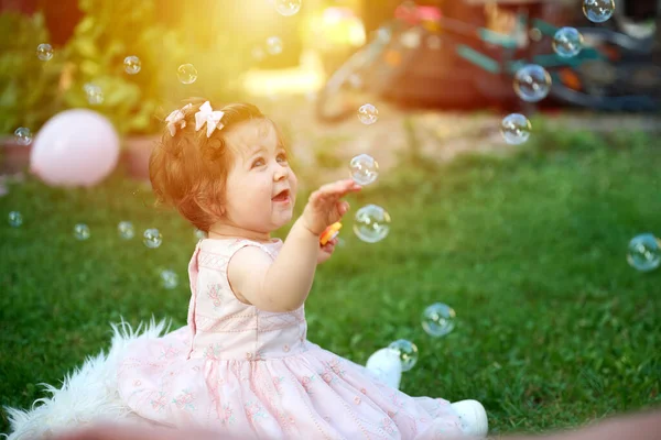 庭の草の上にいる愛らしい女の子 ポートレートを閉じる 夏の風景にハッピーな女の子 屋外にいる小さな子供たち 子供は石鹸の泡で遊んでいる — ストック写真