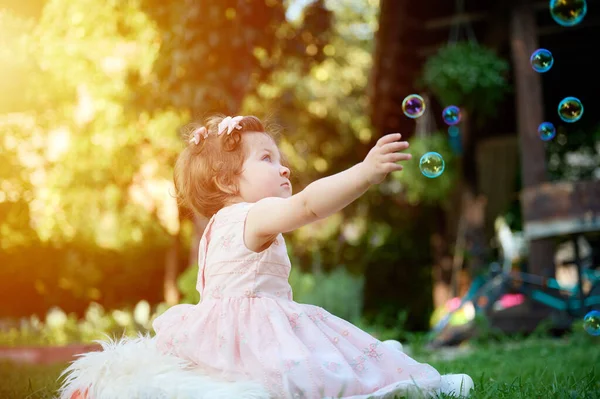 可爱的女孩在花园里的草地上 关门的肖像 在夏日的风景中快乐的小女孩 可爱的孩子在户外 小孩玩肥皂泡 — 图库照片