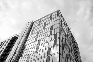 Yeni iş bölgesinde mavi gökyüzüne karşı modern binanın alt manzarası. Modern bir apartmanın ön cephesi. Kentsel bina tasarımı konsepti. Ivano-Frankivsk, Ukrayna - 09.26.2023