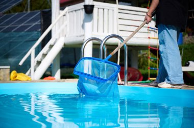 Hevesli temizleyici çalışmaya hazır. Genç bir bayan yüzme havuzları için temizlik malzemesi tutuyor. Havuz temizleyicisiyle bilardo oynayan pozitif kız..