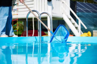 Hevesli temizleyici çalışmaya hazır. Genç bir bayan yüzme havuzları için temizlik malzemesi tutuyor. Havuz temizleyicisiyle bilardo oynayan pozitif kız..