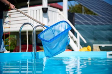 Hevesli temizleyici çalışmaya hazır. Genç bir bayan yüzme havuzları için temizlik malzemesi tutuyor. Havuz temizleyicisiyle bilardo oynayan pozitif kız..