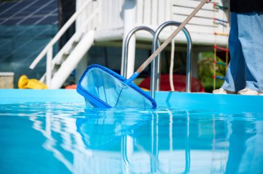 Hevesli temizleyici çalışmaya hazır. Genç bir bayan yüzme havuzları için temizlik malzemesi tutuyor. Havuz temizleyicisiyle bilardo oynayan pozitif kız..