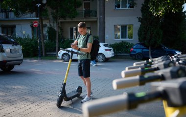 Genç bir turist elektroşok cihazı alıyor. Akıllı telefonunu scooter 'a bağlamaya çalışan odaklanmış bir adam. Genç erkek elektrikli aracın nasıl kullanıldığını anlayamaz..