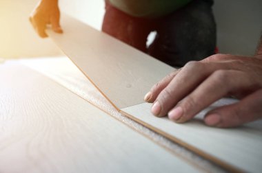 Efendi daireye yeni bir kat kuruyor. Yeni eve kaplama montajı kavramı. Parke ve kaplama döşeme. Ekin manzarası. Daire Yenileme