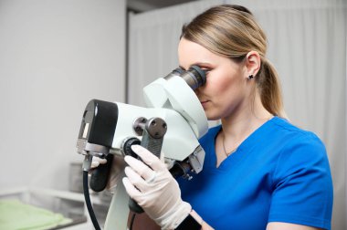 Koloskopiye hazırlanan steril eldivenli güzel bayan doktor. Jinekolog kadın jinekoloji ofisinde bir koloskopun yanında oturuyor. Kadın sağlığı. Kanser erken teşhis edildi.