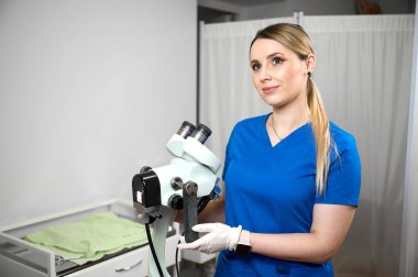Koloskopiye hazırlanan steril eldivenli güzel bayan doktor. Jinekolog kadın jinekoloji ofisinde bir koloskopun yanında oturuyor. Kadın sağlığı. Kanser erken teşhis edildi.