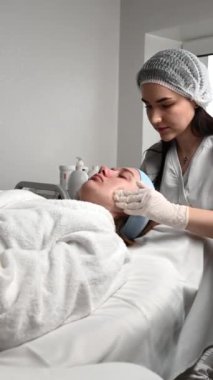 Güzellik kliniğindeki ultrason cilt temizleme ve yüz soyma prosedürünü kapat. Kadının ultrasonik yüz bakımı sırasında makro görüntüsü. Derin gözenek temizleme tedavisi