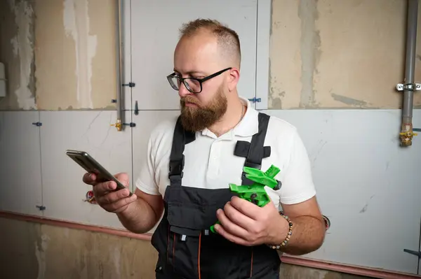 stock image Laying Ceramic Tiles. Tiler placing ceramic wall tile in position over adhesive, process of laying tiles on the SVP Base, Tile Leveling System. Experienced repairman man placing large size tiles.