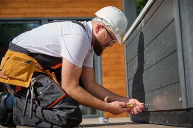 Tesisatçı jakuzi kuruyor. Kaplıca teknisyeni jakuzi yapıyor. Küvet tesisatı. Tesisatçı kaplıcayı tamir ediyor. Üniformalı bir uzman, şık bir bahçe avlusunda bir jakuzi hazırlıyor ve inceliyor..