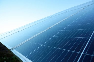 Güneş çiftliğindeki fotovoltaik güneş hücrelerine sabahın erken saatlerinde yakından bakın. Güneş pili çiftliği elektrik santrali. Güneş paneli dokusu arkaplanı