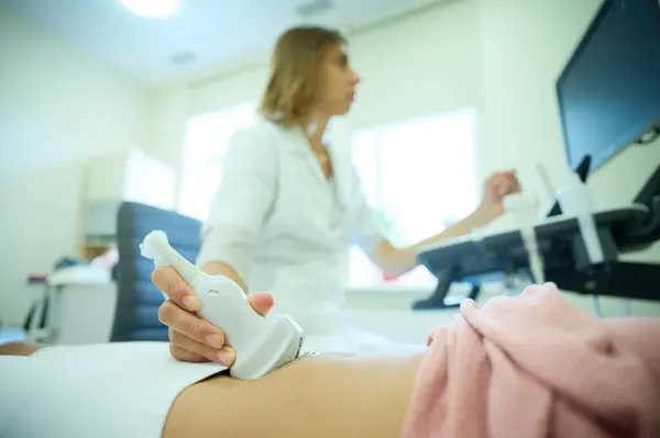 Pediatrik ultrason taraması. Çocuk ultrasonu. Çocuk doktoru karın boşluğunu tarıyor. Doktorun ergenler için organ sonogramı yapmasına yakın çekim. Klinikte ultrason muayenesi. Modern tıbbi ekipman.