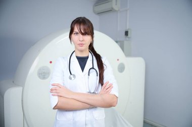 Genç bayan radyologlar tomografi odasında kalıyorlar. Klinikte çalışıyorum. Güzel doktor röntgen, röntgen, tomografi ve MRI 'ya bakıyor. Üniformalı doktor.