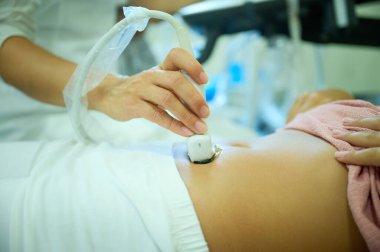 Pediatrik ultrason taraması. Çocuk ultrasonu. Çocuk doktoru karın boşluğunu tarıyor. Doktorun ergenler için organ sonogramı yapmasına yakın çekim. Klinikte ultrason muayenesi. Modern tıbbi ekipman.