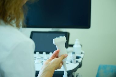 Doktorun ultrason sondası tutarken görüntüsü hastayı taramaya hazırlanıyor. Ultrasonografi özel ekipmanlarını kapat, doktor eli ultrason sondası tutuyor..