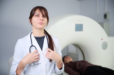 Tarama odasında hastası olan bir kadın radyolog. Tomografi odasında sevimli bir doktor. Radyolog, bilgisayarlı tomografi odasında bir kadın hasta ile birlikte. Modern klinik. Radyoloji Bölümü.