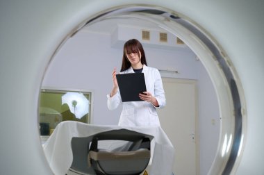 Genç bayan radyologlar tomografi odasında kalıyorlar. Klinikte çalışıyorum. Güzel doktor röntgen, röntgen, tomografi ve MRI 'ya bakıyor. Üniformalı doktor.