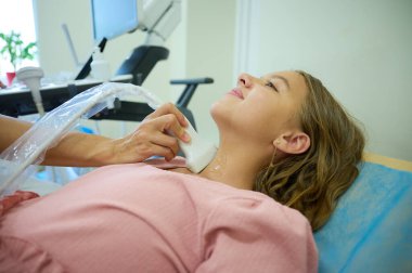 Doktorun çocuk için tiroit sonogramı yapmasına yakın çekim. Pediatrik ultrason taraması. Çocuk ultrasonu. Pediyatrist boynu tarıyor. Lenf düğümlerinin ultrason incelemesi. Çocukluk hastalıkları