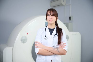 Genç bayan radyologlar tomografi odasında kalıyorlar. Klinikte çalışıyorum. Güzel doktor röntgen, röntgen, tomografi ve MRI 'ya bakıyor. Üniformalı doktor.